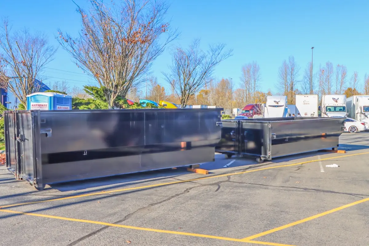 Professional dumpster rental service with roll-off container on residential driveway in Mack